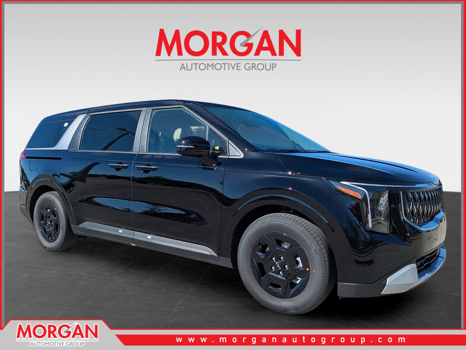 2026 Kia Carnival LXS in Aurora Black Pearl — front three-quarter view